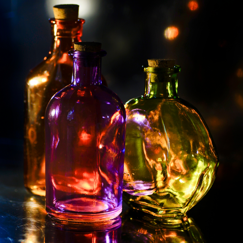 Three glass bottles are sitting on a table.